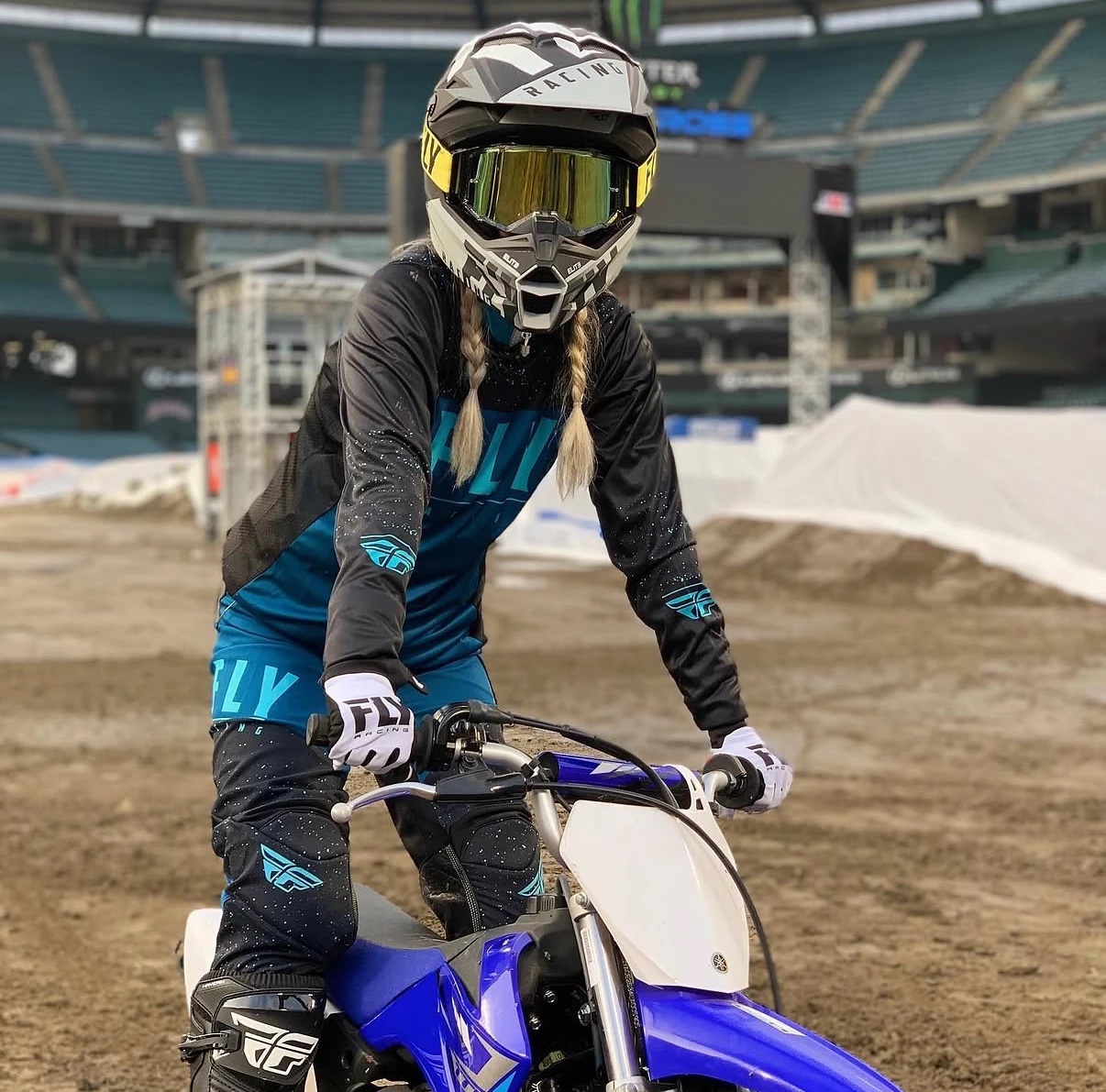 Nikki Kay in full gear on a motocross bike at a stadium track