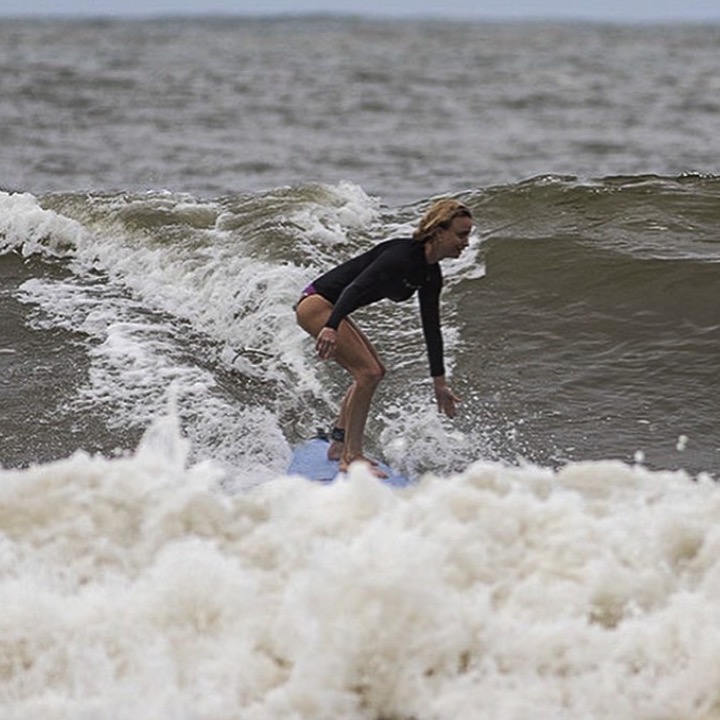 Nikki Kay riding a wave on a surfboard